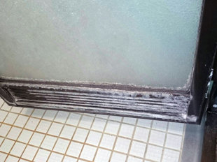 カビや水垢で汚れた浴室のドア